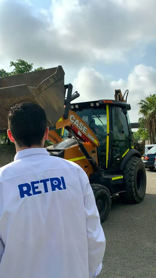 Supervisor de Retri frente a una retroexcavadora CASE 580N